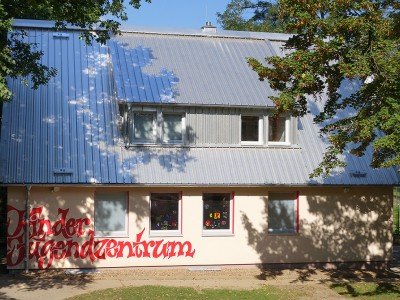 Hausfassade zwischen Baeumen